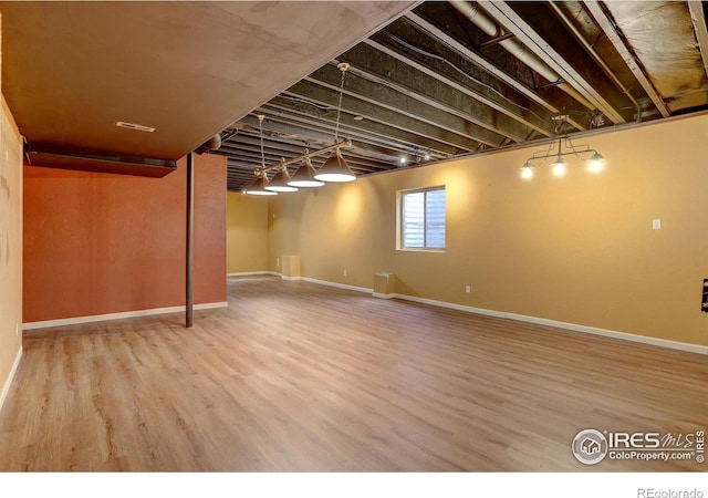 basement featuring wood finished floors and baseboards