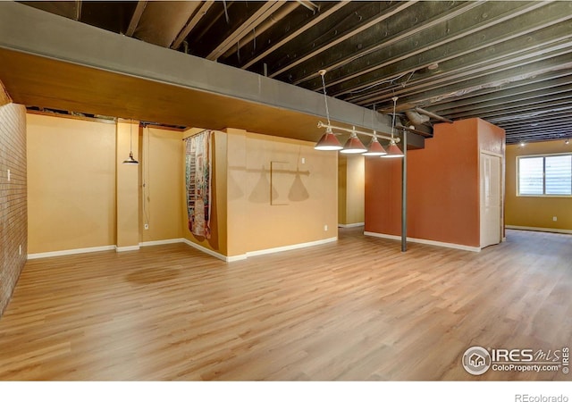 below grade area featuring wood finished floors and baseboards