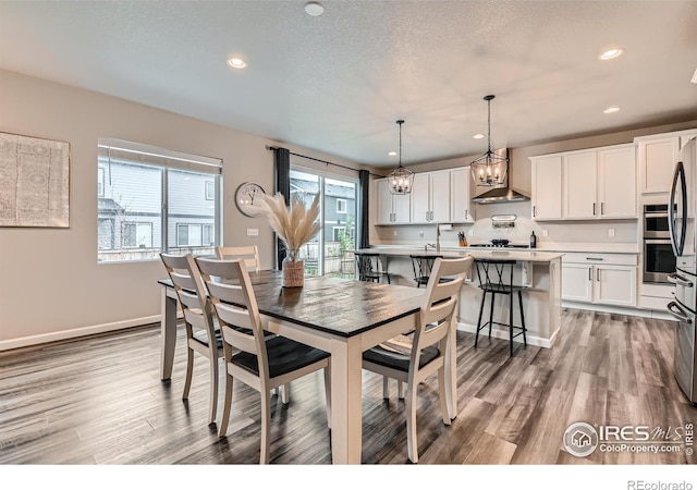dining room with light wood-type flooring, recessed lighting, and baseboards