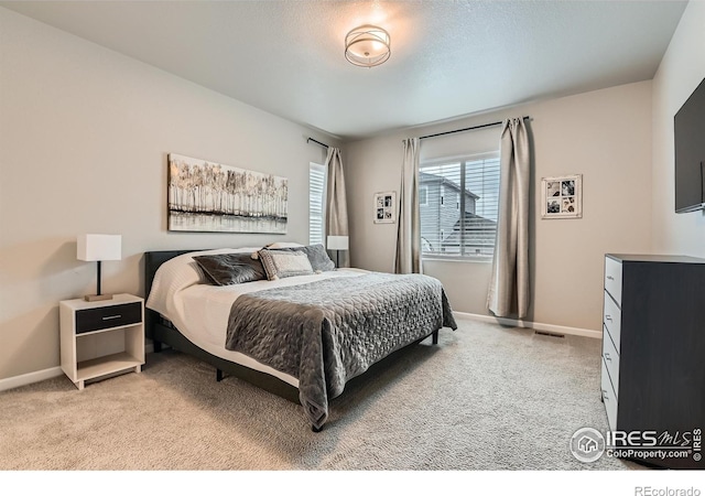 bedroom featuring light carpet and baseboards