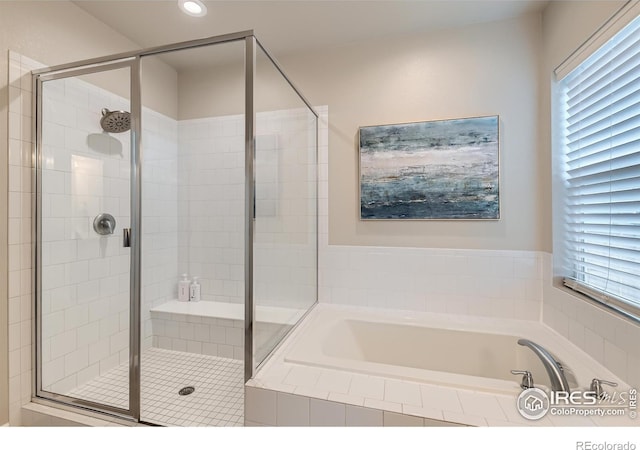 bathroom with a bath, a shower stall, plenty of natural light, and recessed lighting