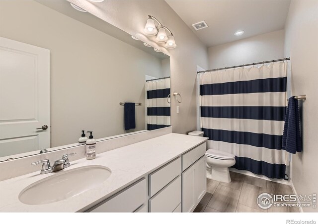 bathroom featuring vanity, toilet, and curtained shower