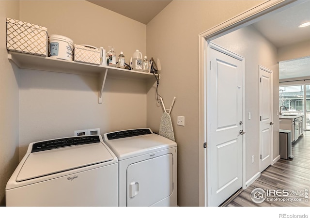 washroom with washer and clothes dryer and wood finished floors