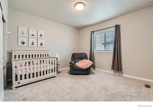 bedroom featuring baseboards, carpet, and a crib