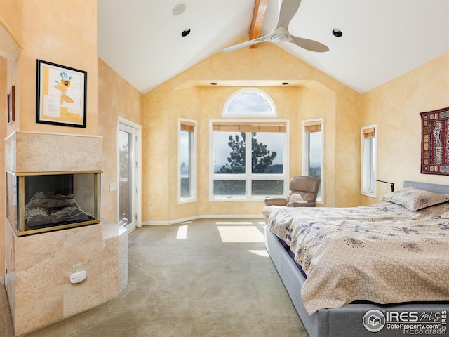 carpeted bedroom featuring multiple windows, high vaulted ceiling, baseboards, a tile fireplace, and beam ceiling