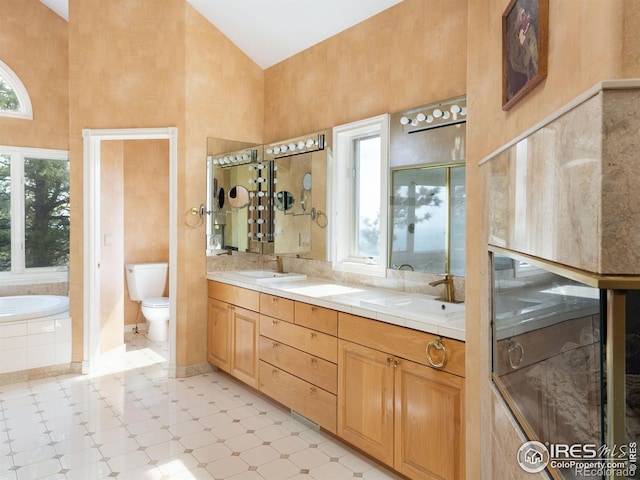 full bathroom featuring high vaulted ceiling, toilet, double vanity, and a bath
