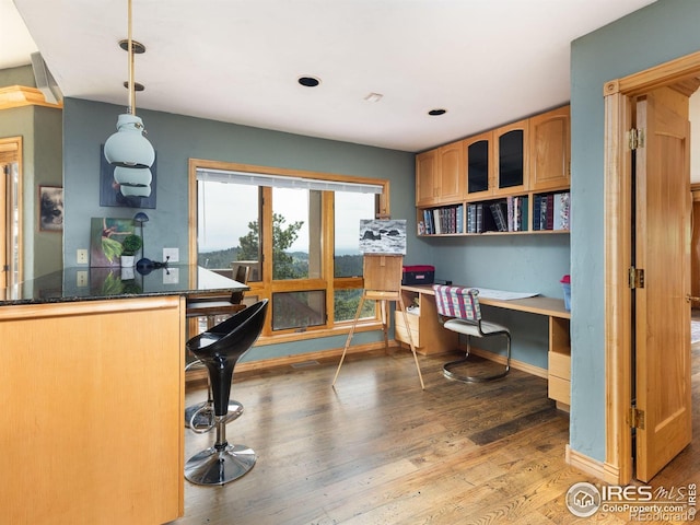 office space with built in study area, light wood-style flooring, and baseboards