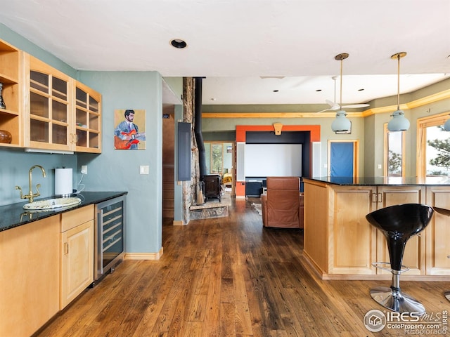 kitchen featuring wine cooler, light brown cabinetry, dark wood-type flooring, open shelves, and a wood stove