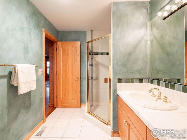 full bath with a stall shower, tile patterned floors, and vanity
