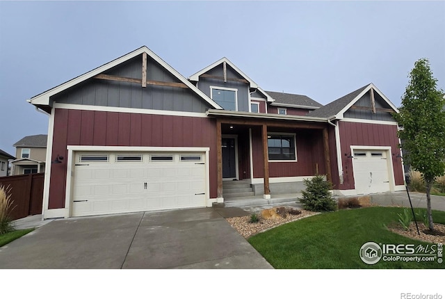 view of front of house with driveway, a front lawn, a garage, and a porch