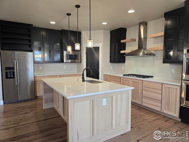 kitchen with stainless steel appliances, open shelves, a sink, wall chimney exhaust hood, and backsplash