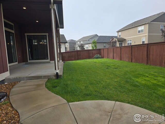 view of yard with a residential view and a patio
