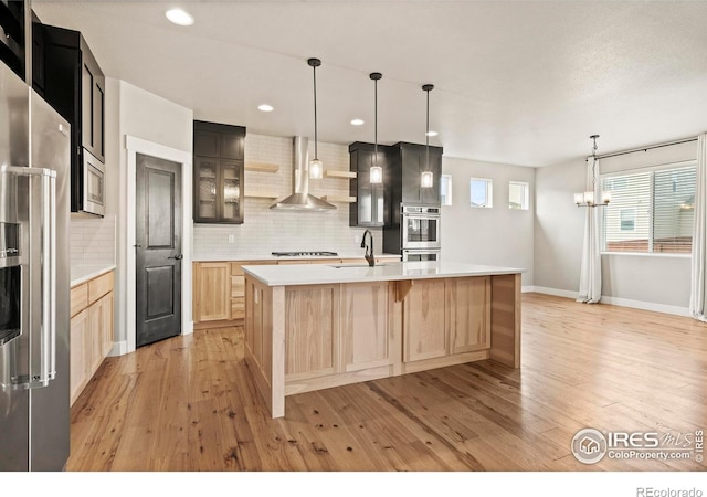 1940 Rolling Wind Dr, Windsor, CO 80550 - kitchen featuring wall chimney exhaust hood, high end refrigerator, light brown cabinets, light wood finished floors, and tasteful backsplash