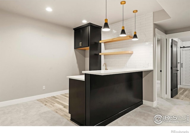1940 Rolling Wind Dr, Windsor, CO 80550 - kitchen with light countertops, dark cabinets, light wood-type flooring, baseboards, and hanging light fixtures
