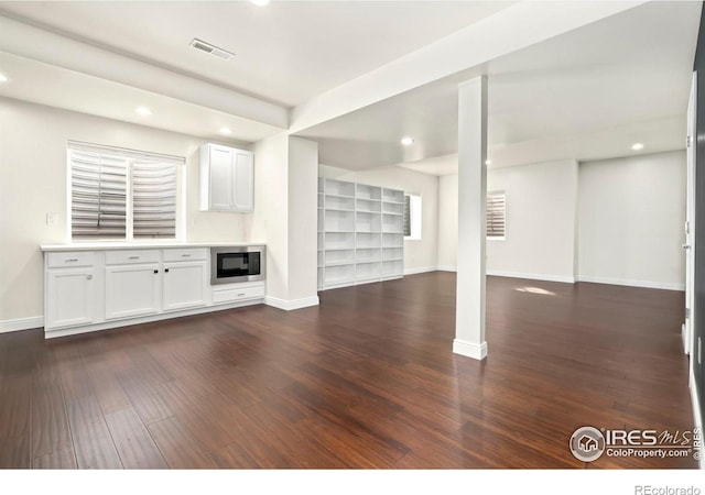 unfurnished living room with dark wood-style floors, baseboards, and recessed lighting