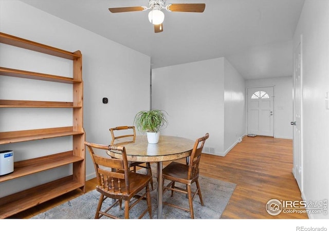 dining space featuring ceiling fan, wood finished floors, and baseboards
