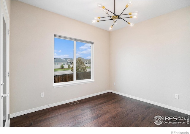 6725 2nd St, Frederick, CO 80530 - unfurnished room featuring a chandelier, dark wood-type flooring, and baseboards