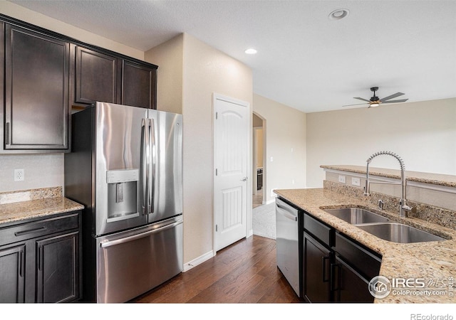 6725 2nd St, Frederick, CO 80530 - kitchen with stainless steel appliances, a sink, dark wood-style floors, arched walkways, and a ceiling fan
