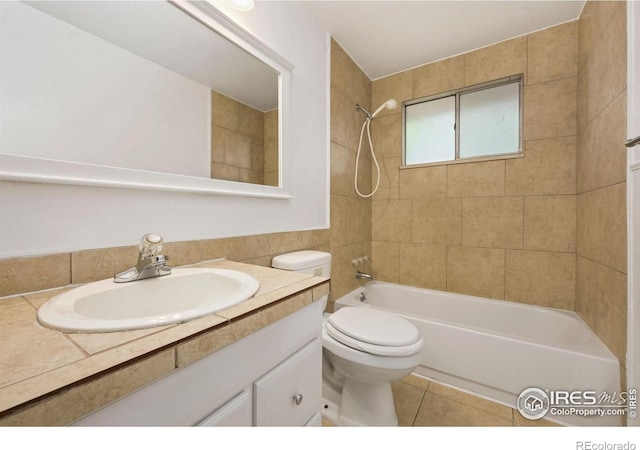 bathroom with  shower combination, toilet, vanity, tile patterned floors, and tile walls
