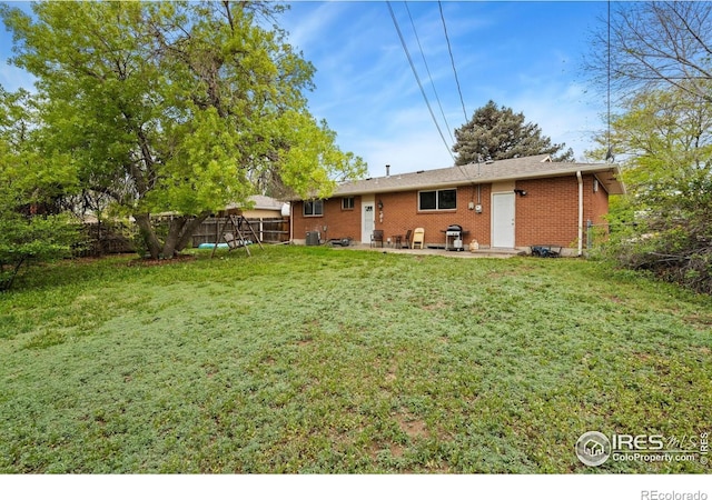 rear view of property with brick siding and a patio area