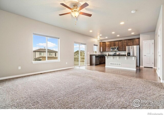 unfurnished living room with light carpet, recessed lighting, baseboards, and ceiling fan