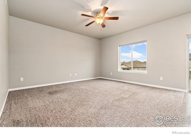 spare room with ceiling fan, carpet floors, and baseboards