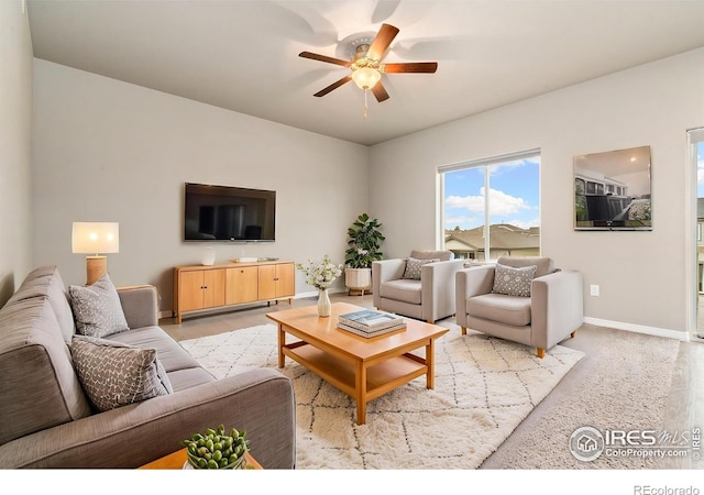 living room featuring ceiling fan and baseboards