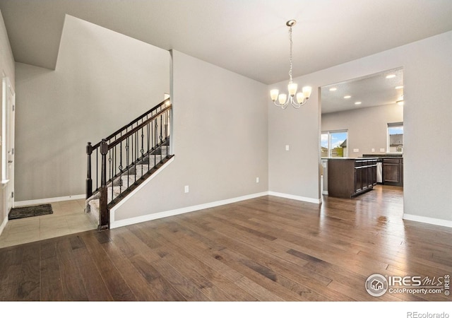 unfurnished living room featuring wood-type flooring, a chandelier, stairway, baseboards, and recessed lighting