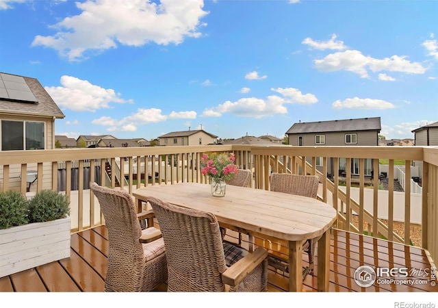 wooden deck with a residential view and outdoor dining space