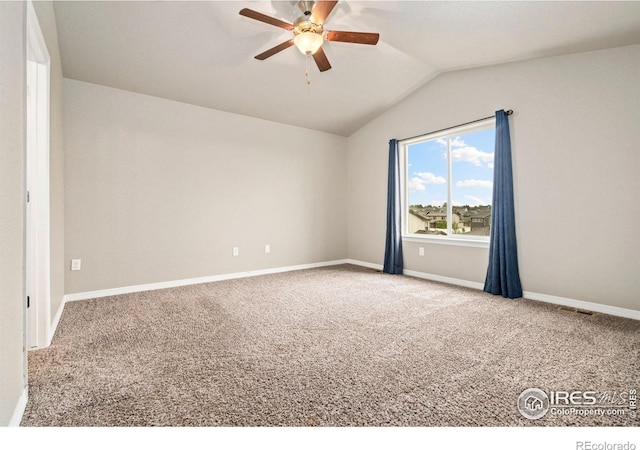 spare room featuring ceiling fan, carpet, vaulted ceiling, and baseboards