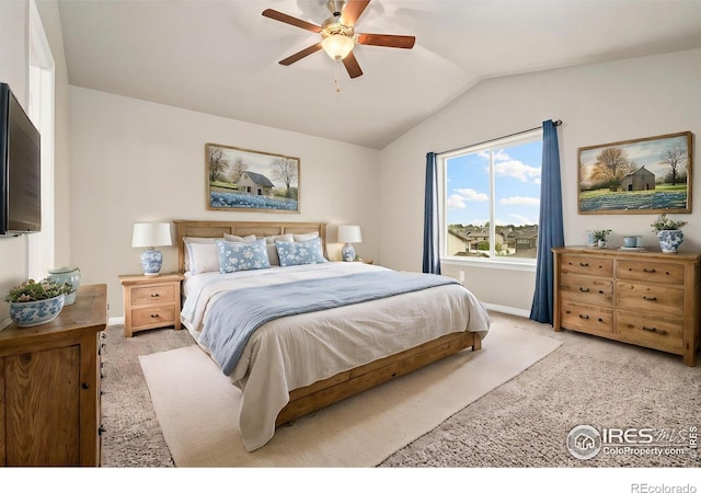 bedroom with lofted ceiling, light colored carpet, baseboards, and a ceiling fan