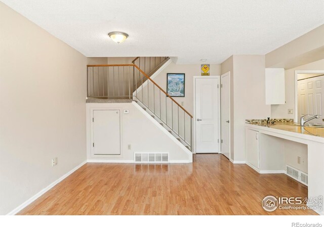 4160 Monroe Dr Unit B, Boulder, CO 80303 - interior space with light wood-style flooring, stairs, baseboards, a sink, and a textured ceiling
