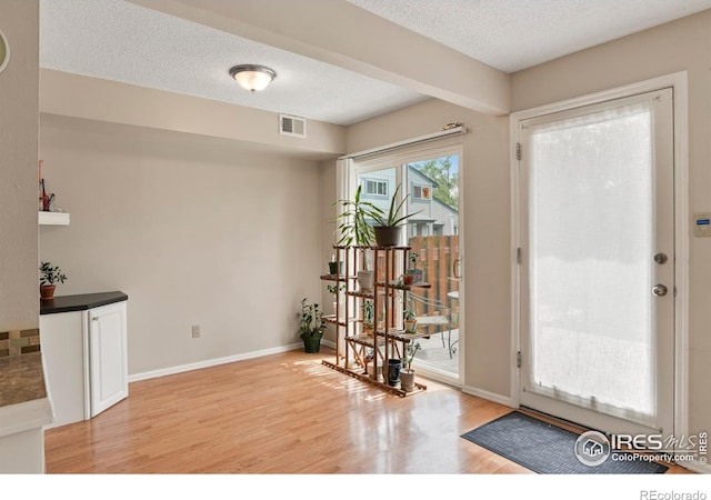 4160 Monroe Dr Unit B, Boulder, CO 80303 - doorway to outside with light wood-style flooring, a textured ceiling, and baseboards