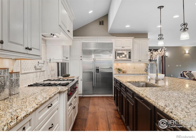 kitchen featuring built in appliances, a sink, white cabinets, dark wood finished floors, and recessed lighting