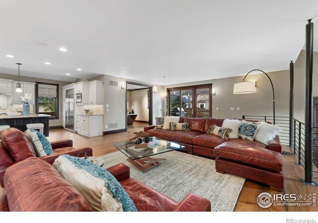 living area featuring light wood finished floors, plenty of natural light, and recessed lighting