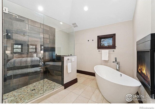 full bath with a stall shower, a freestanding bath, tile patterned floors, baseboards, and recessed lighting