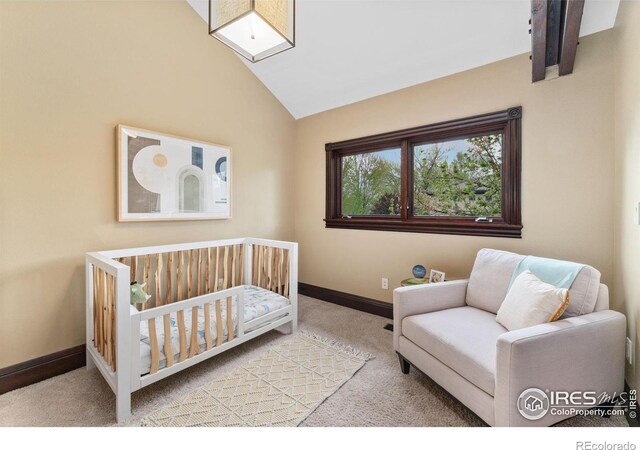 bedroom with carpet, vaulted ceiling, baseboards, and a crib