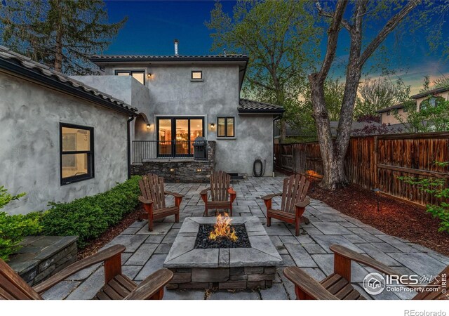 view of patio / terrace with a fire pit and fence