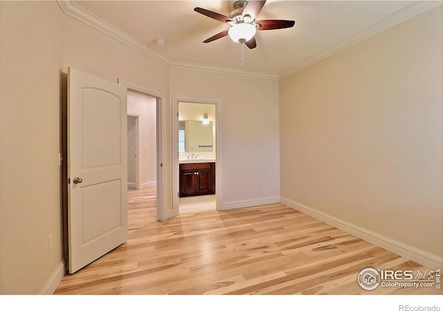 empty room with ceiling fan, light wood-type flooring, crown molding, and baseboards
