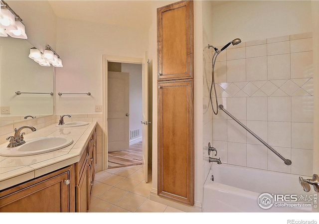 bathroom featuring double vanity, tile patterned flooring, and shower / bathtub combination
