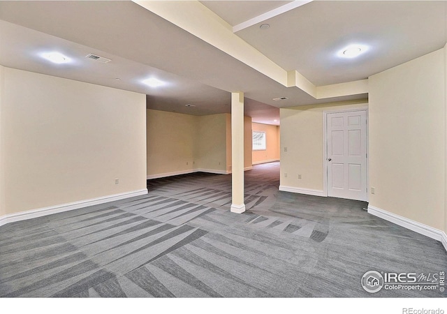 finished below grade area featuring dark colored carpet and baseboards