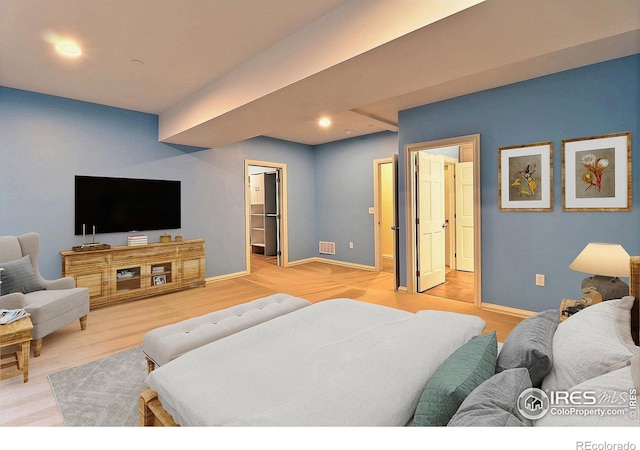 bedroom featuring a spacious closet, baseboards, light wood-style floors, and recessed lighting