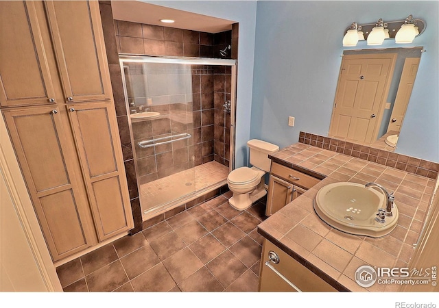 full bathroom with a shower stall, toilet, vanity, and tile patterned floors