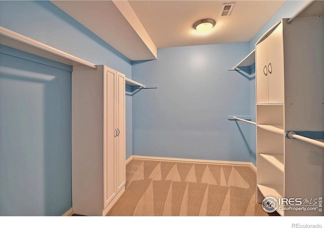 walk in closet with carpet flooring
