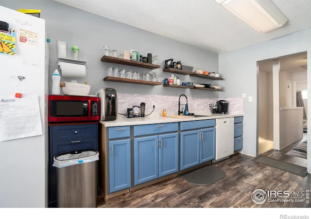 bar area with white appliances, a sink, dark wood-type flooring, backsplash, and a textured ceiling