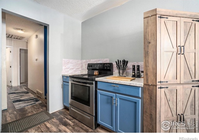 kitchen featuring stainless steel range with electric stovetop, blue cabinetry, a textured ceiling, light countertops, and dark wood-style floors
