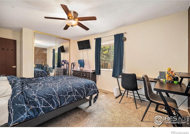 bedroom featuring carpet, a closet, a textured ceiling, and a ceiling fan