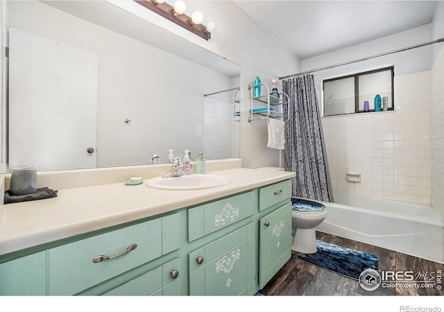 bathroom featuring wood finished floors, toilet, vanity, and shower / tub combo