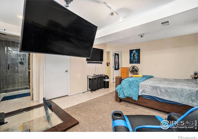 bedroom featuring rail lighting, baseboards, and ensuite bath