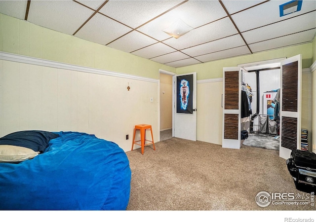 carpeted bedroom with a paneled ceiling